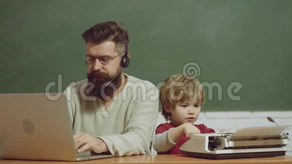 桌子上有旧打字机和笔记本电脑技术进步的概念一对父子老年人和年轻人视频的预览图