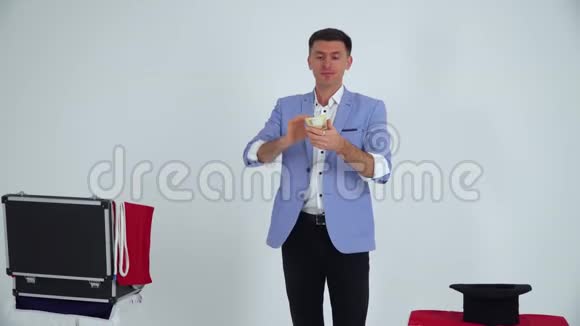 穿西装的魔术师在白色背景下用金钱表演魔术视频的预览图