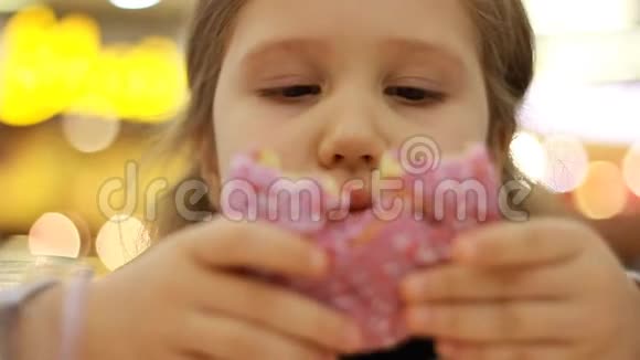 孩子吃甜甜圈特写小女孩吃甜甜圈加糖好吃的甜的甜的视频的预览图