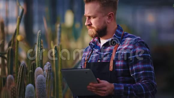 在农业温室里漂亮的园丁带着电子平板电脑做了一些关于条件的笔记视频的预览图