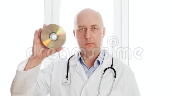 秃头医生在白色窗口背景上显示光盘前置摄像头医务工作者手持DVD数据盘和视频的预览图
