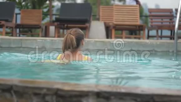 带马尾辫的年轻女子在棕色游泳池游泳视频的预览图