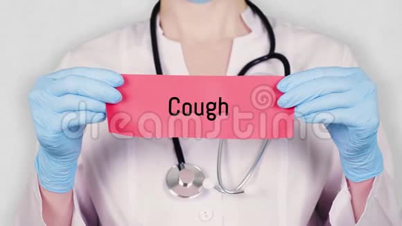 特写镜头中双手戴着蓝色的医用手套手里拿着一张写着咳嗽的红色纸牌穿白衣服的医生视频的预览图