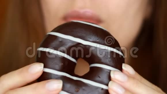特写女人吃巧克力甜甜圈好吃甜牙甜饮食节食女人的嘴咬着甜点视频的预览图