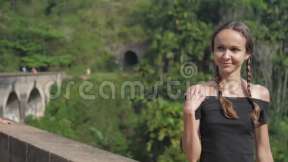 女孩坐在著名的桥上享受野生热带自然视频的预览图