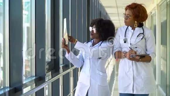 两位非裔美国女医生检查肺部x光手拿在室内两名专家视频的预览图