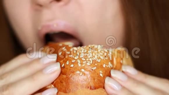 女人吃汉堡包口和食物特写吃快餐女性手中的汉堡选择性重点视频的预览图