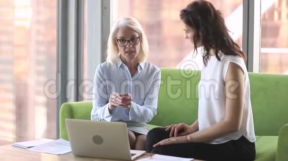 高级职业经理人导师指导年轻女性实习生使用手提电脑视频的预览图