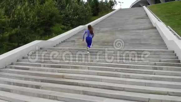 年轻有魅力的运动女性在城市沥青上跑步和早晨锻炼后侧的俯视图视频的预览图