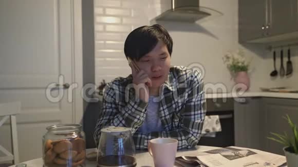 亚洲男人在家厨房里用手机说话视频的预览图