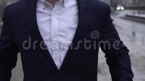 特写镜头商人穿着白色衬衫和蓝色夹克走在街上接电话穿西装的男人视频的预览图