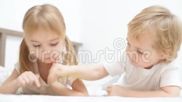 可爱的金发孩子在灯光下玩平板电脑游戏视频的预览图
