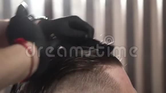穿着黑色手套的理发师用梳子和剪刀把头发剪短最接近的镜头视频的预览图