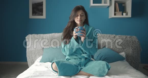 女人在床上喝热咖啡视频的预览图