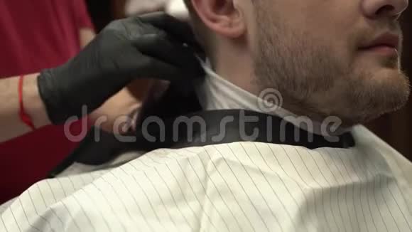 专业理发师用毯子覆盖客户近距离射击视频的预览图