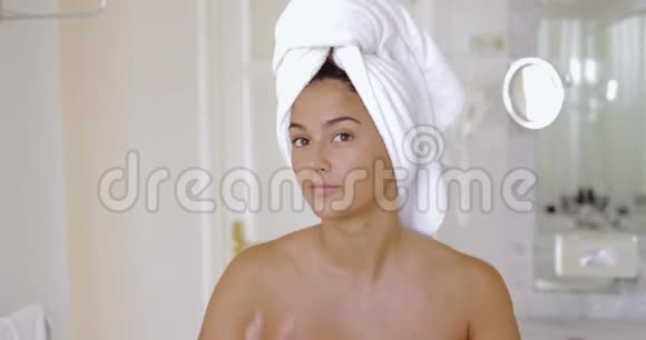 年轻漂亮女人头上戴着毛巾看着镜头视频的预览图