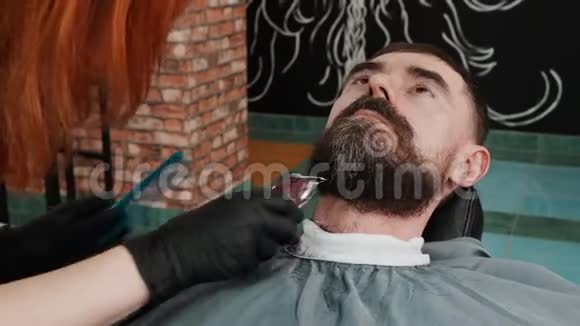 为客户修剪胡须的女理发师特写镜头视频的预览图