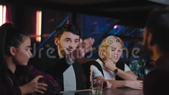 在一个现代酒吧里男人和女人在喝威士忌的时候花了很长时间他们和酒保聊天视频的预览图