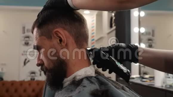 有胡须的嬉皮士肖像用电动修边器刮颈发型师在男性颈部剃毛视频的预览图