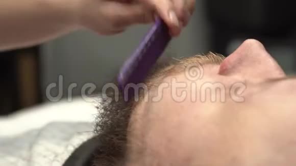 为留胡子的家伙合上剪胡子的录像女人在理发店为男人修剪胡须视频的预览图