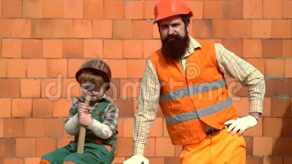 父亲和小儿子在车间用钻穿木板父子一起建房子小孩小孩视频的预览图
