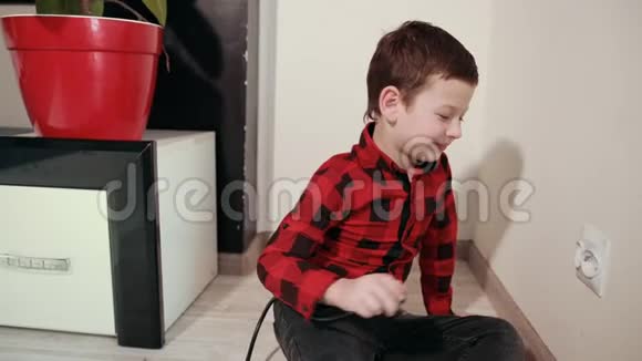 一个穿着红色和黑色格子衬衫的帅哥把一个电插头插入插座视频的预览图