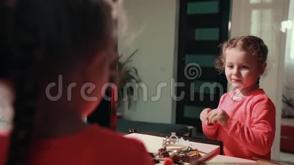 穿着粉红色连衣裙的小可爱女孩把发夹放在头上视频的预览图