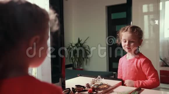 穿着粉红色裙子的女孩很性感她看着镜子里的自己挥动着她的手视频的预览图