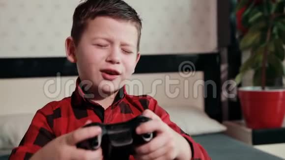 可爱的男孩玩电子游戏拿着操纵杆有感情的时间视频的预览图
