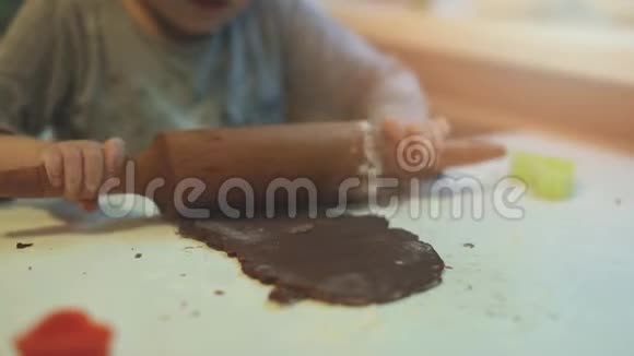 小女孩在厨房的桌子上擀姜饼面团视频的预览图