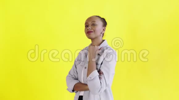 年轻快乐的非洲女人在黄色背景的Jean夹克上竖起大拇指视频的预览图