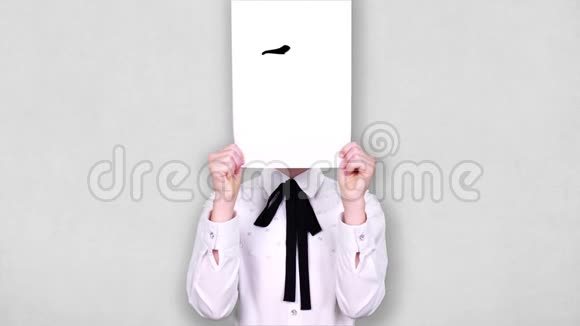 肖像少年手持白纸片用迷茫的笑脸画动画遮脸情感想象视频的预览图
