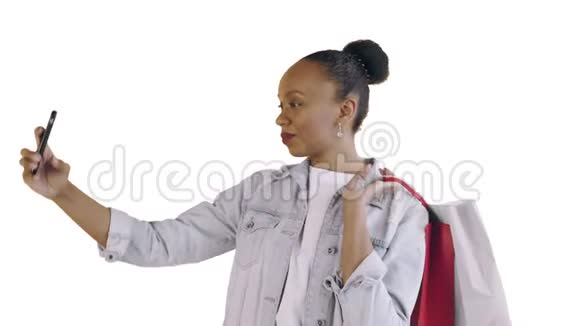 美国黑人妇女带着购物袋的肖像正在工作室的白色背景上自拍琼夹夹克视频的预览图