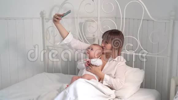 妈妈带着婴儿床带着智能手机视频的预览图