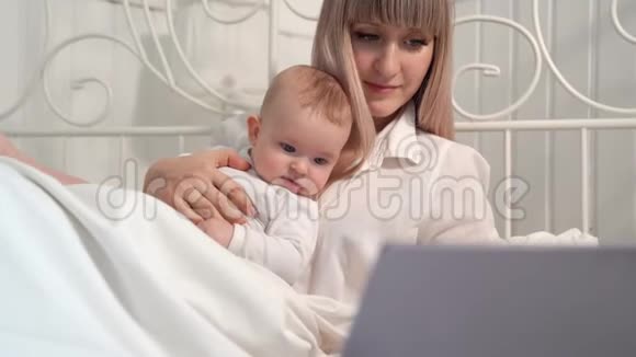 一位母亲躺在床上带着婴儿用电脑工作视频的预览图
