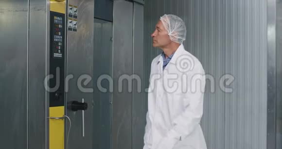 一位老人食品工程师和他的助手有一个检查站让一个穿着白色制服的面包机女工帮忙视频的预览图