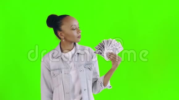 体贴成功的非洲裔美国妇女带着绿色背景的钱让夹克视频的预览图