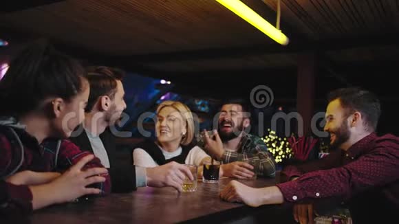 一大群相貌英俊的朋友微笑着晚上一起在酒吧酒吧招待看着他们微笑着视频的预览图