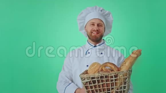 贝克盖伊非常有魅力微笑着在镜头前的绿色工作室他闻到新鲜的面包和视频的预览图