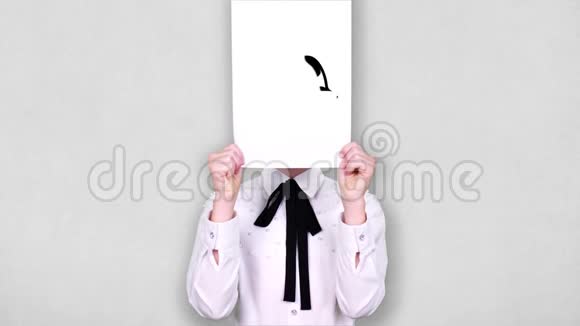 肖像少年手持白纸单用失望的笑脸画动画遮脸情绪情绪视频的预览图