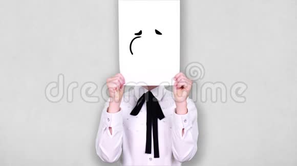 肖像少年手持白纸张用疯狂的笑脸画动画遮脸情感想象视频的预览图
