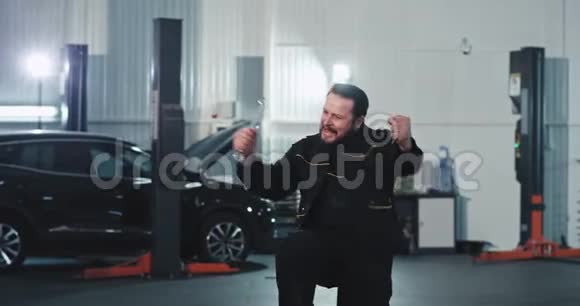在现代汽车服务中心快乐而兴奋的机械师在跳舞充满魅力和激动视频的预览图