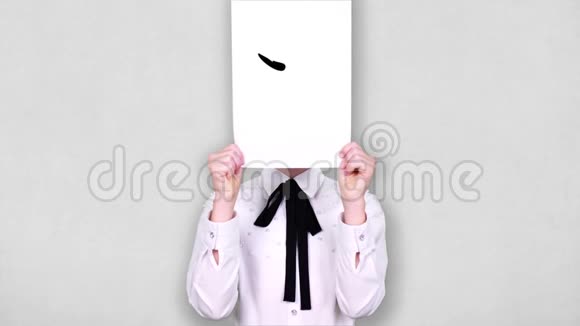 肖像少年手持白纸片带着焦急疑惑的笑脸画图动画遮脸情绪情绪视频的预览图