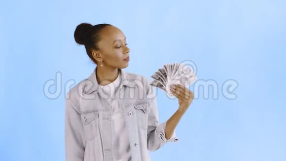 体贴成功的非裔美国女人带着蓝色背景的钱让夹克视频的预览图