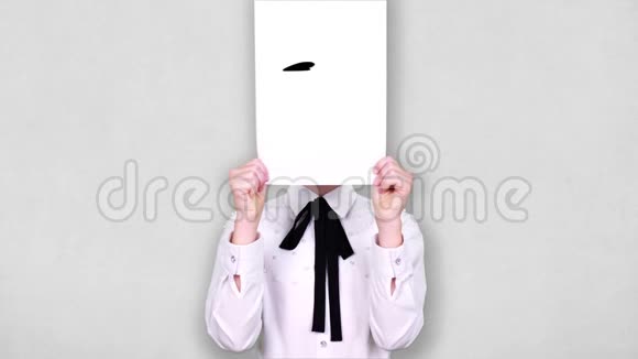 肖像少年手持白纸张用紧张的笑脸描画动画遮脸情感想象视频的预览图