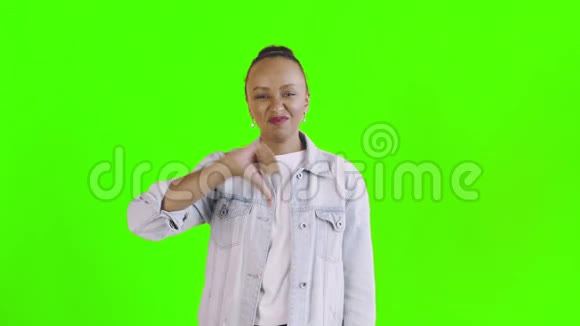 年轻不快乐的非裔美国妇女在绿色背景的Jean夹克衫上大显身手视频的预览图