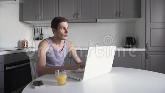 年轻人在笔记本电脑上工作在家里用电话体贴的商人视频的预览图