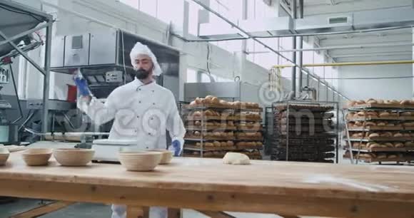 兴奋的面包师带着胡子跳舞在他的工作地点在商业厨房他享受时间而移动有趣视频的预览图