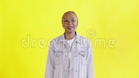 满意的兴奋的兴奋的非裔美国妇女在黄色背景的Jean夹克上展示金钱说上帝啊视频的预览图