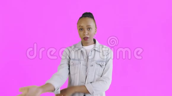 沮丧的非裔美国女孩的肖像困惑地看着镜头上的粉红色背景面部表情视频的预览图